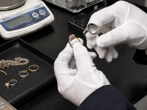 金とプラチナのコンビ製品の刻印や宝石、異素材部分など製品構造を確認している様子